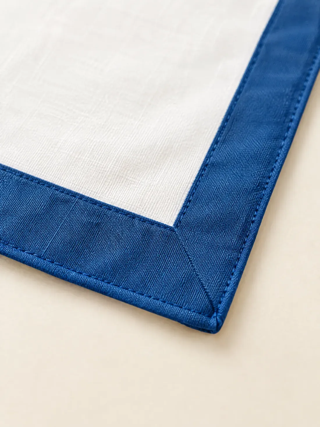 Harbour Bordered Neckerchief, close-up of the corner where the harbour-blue border meets, with rolled hem