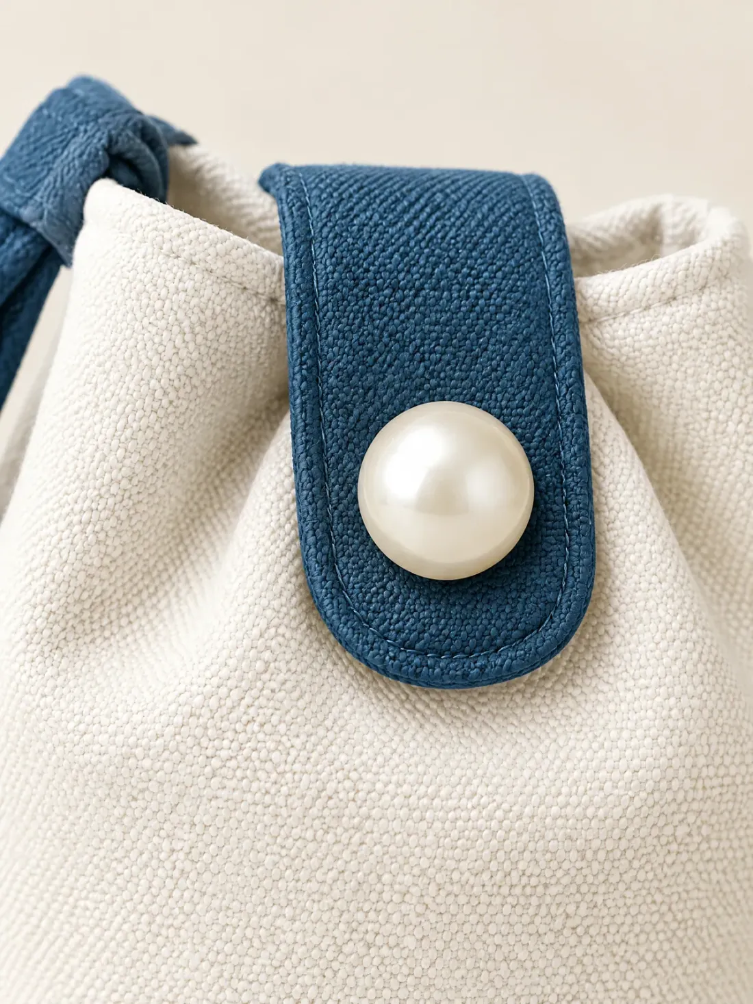 Postcard Button Pouch, close-up of the harbour-blue top tab with the large pearl-tone button