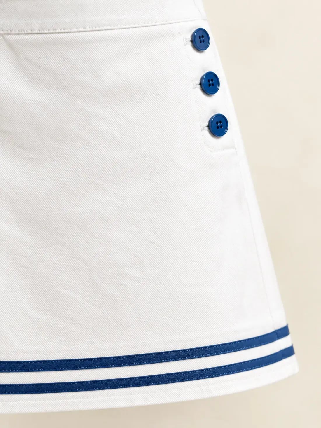 Postcard Stripe Hem Mini, close-up of the double stripe at the hem and the three stacked buttons at the hip